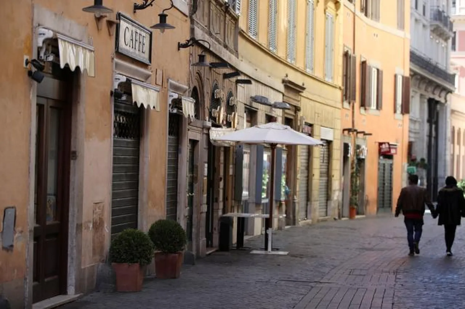 People walk past closed bars and restaurants as Rome becomes a 'red zone', going into lockdown, as the country struggles to reduce the coronavirus disease (COVID-19) infections, in Rome, Italy, March 15, 2021. REUTERS/Yara Nardi
