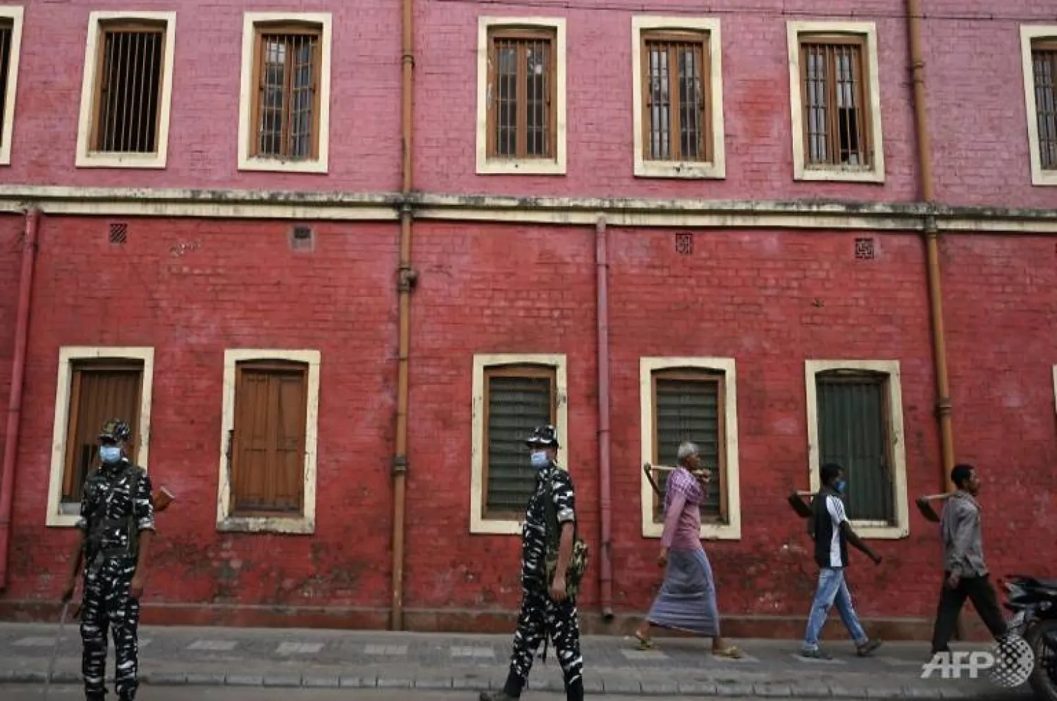 Indian paramilitary personnel stand guard outside a polling station during phase four of West Bengal's legislative elections, in Howrah district near Kolkata | AFP