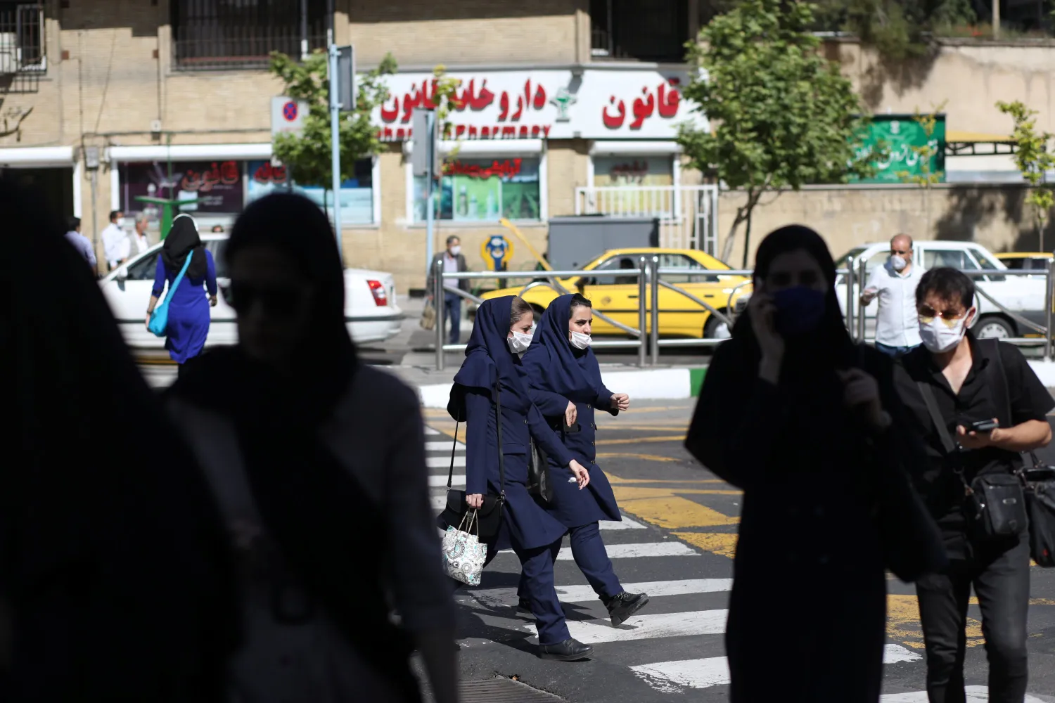 Iranians wear protective face masks and gloves, following the outbreak of the coronavirus disease (COVID-19), as they walk in Vali-E-Asr street, in Tehran, Iran, May 12, 2020. (Reuters Photo)