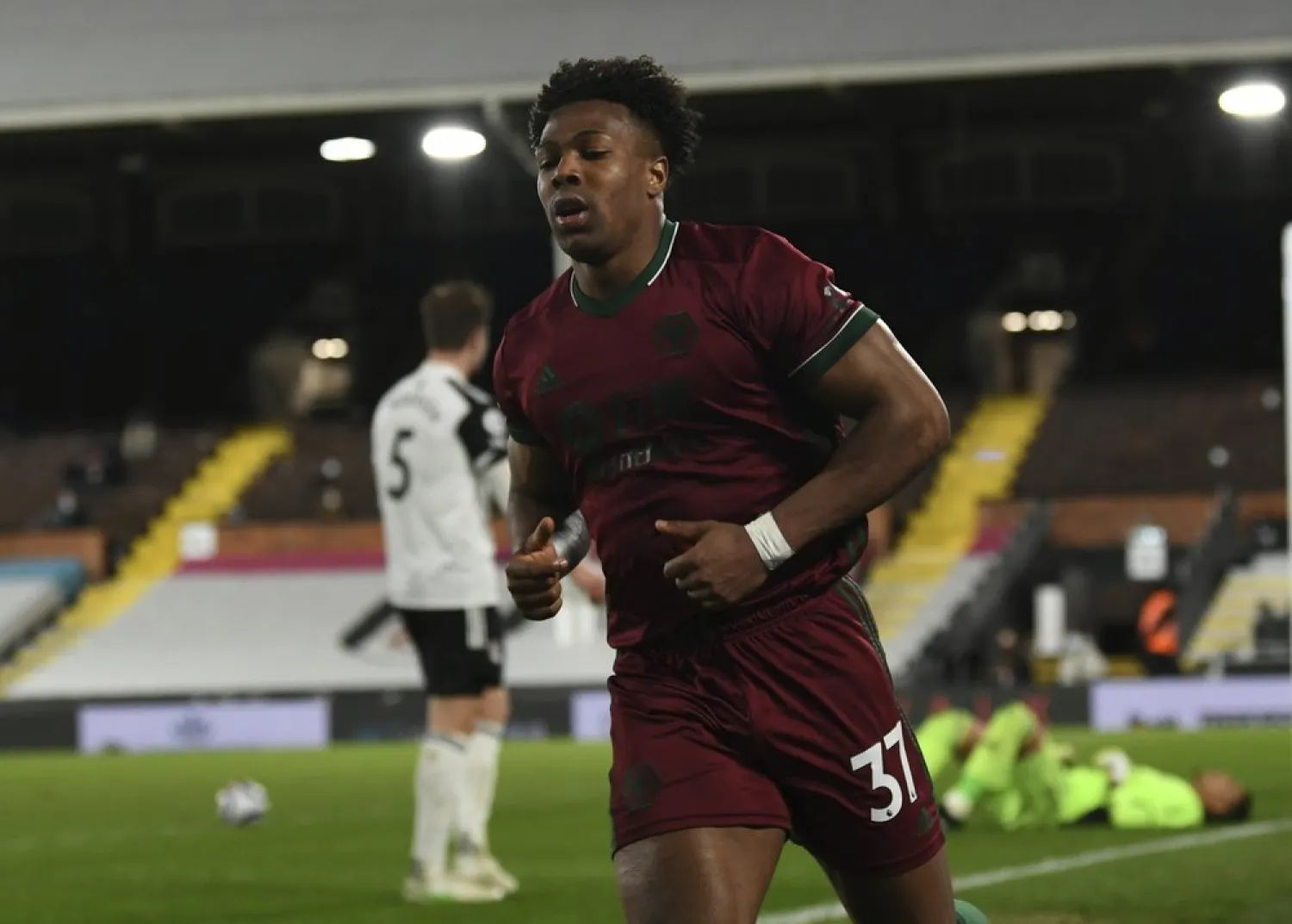 Wolverhampton Wanderers' Adama Traore celebrates scoring their first goal during the match at Craven Cottage stadium in London, England, Friday, April 9, 2021. (AP)