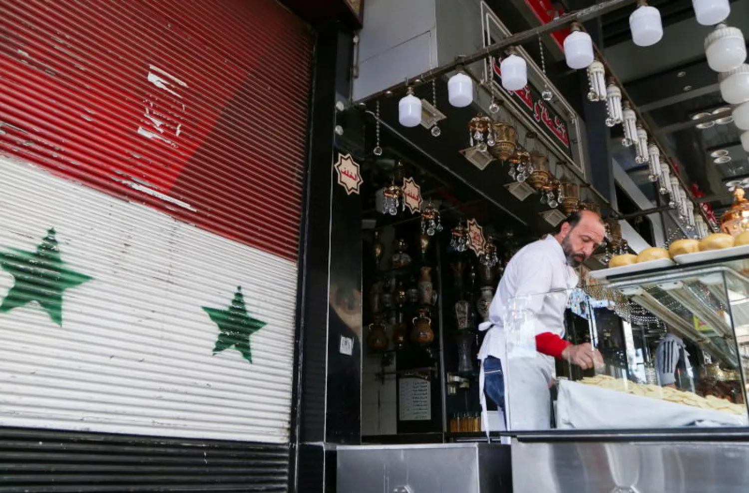 بائع في محل لبيع الحلويات في دمشق (رويترز)