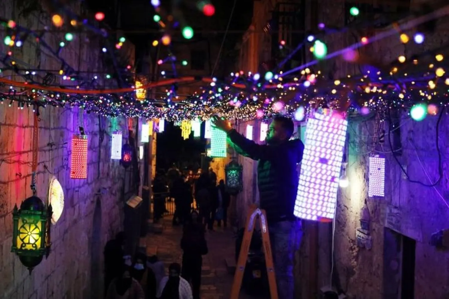 A man sets lights for decoration in an alley in Jerusalem's Old City as part of the preparation for Ramadan as coronavirus restrictions ease around the country April 11, 2021. (Reuters)