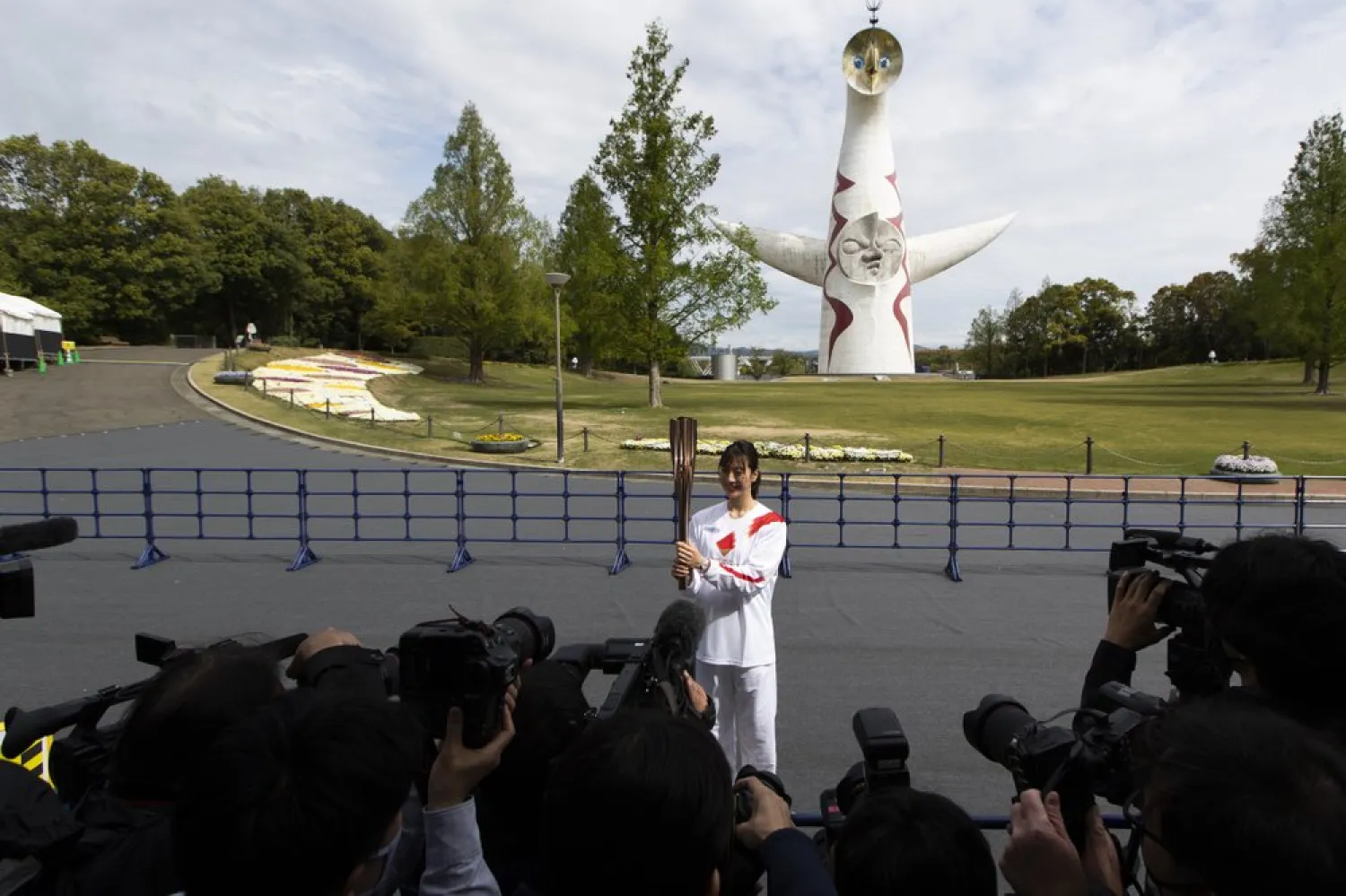 Former Olympian Aya Terakawa, participating as an Olympic torch relay runner, poses for the media before she carries the torch during the first day of the Osaka round at a former Expo site in Suita, north of Osaka, western Japan, Tuesday, April 13, 2021.  (AP Photo/Hiro Komae)
