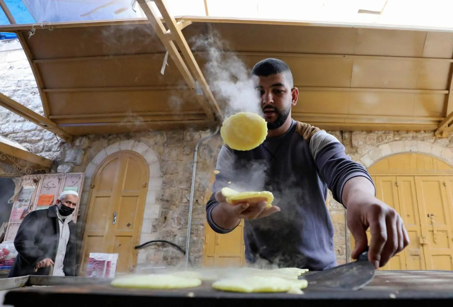 A Palestinian man prepares Qatayef, traditional pancakes that are popular during the fasting month of Ramadan, in the occupied West Bank town of Hebron, ahead of the holy month. (AFP)