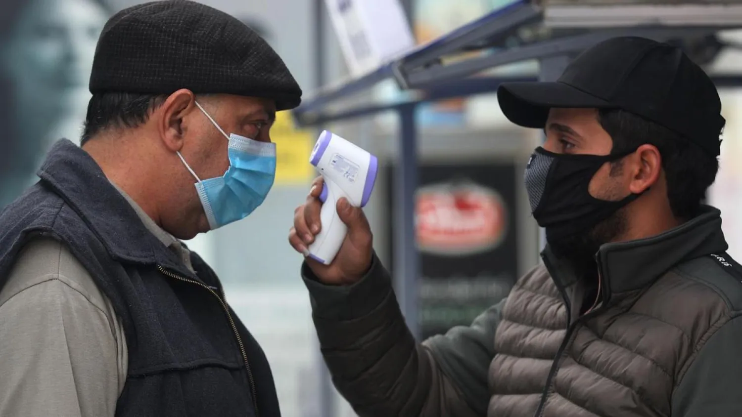  A shopper has his temperature checked outside a supermarket in the Iraqi capital Baghdad on December 18, 2020. AFP
