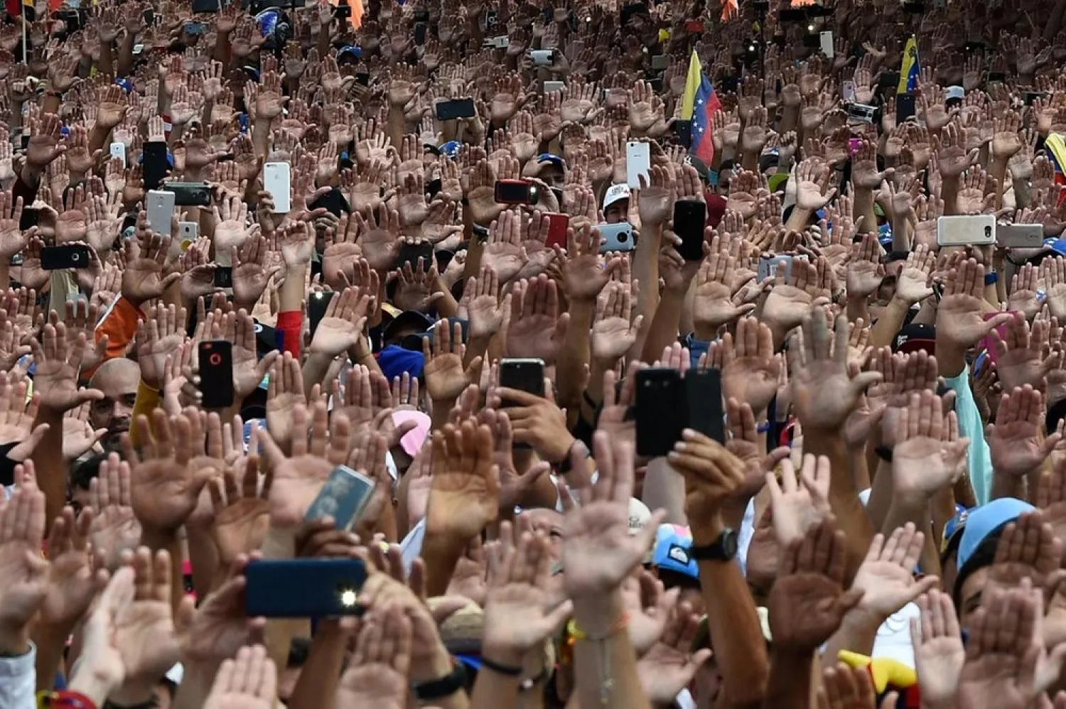 People raise their hands during a mass opposition rally against President Nicolas Maduro in Caracas, Venezuela. (AFP)