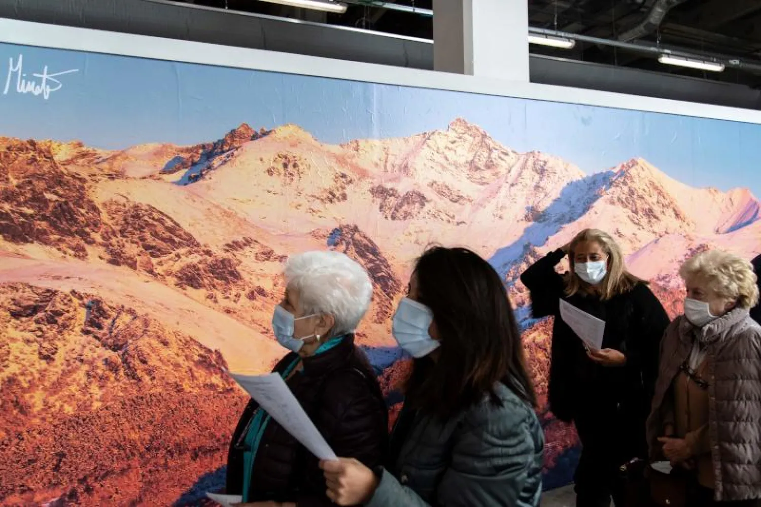 سيدات يصلن إلى مركز للتلقيح في مدينة تورينو الإيطالية (أ.ف.ب)