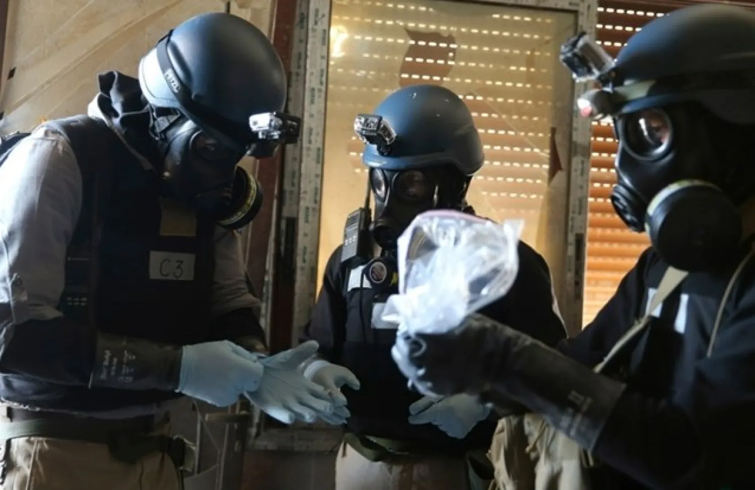 FILE PHOTO: A UN chemical weapons expert, wearing a gas mask, holds a plastic bag containing samples from one of the sites of an alleged chemical weapons attack in the Ain Tarma neighborhood of Damascus August 29, 2013. REUTERS/Mohamed Abdullah