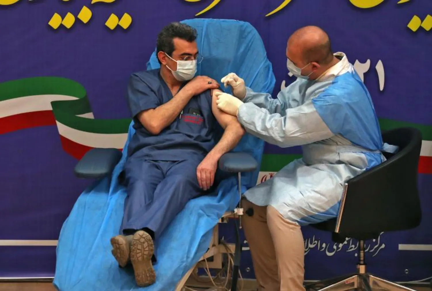 عامل صحي يتلقى جرعة من اللقاح المضاد لفيروس كورونا في طهران (أ.ف.ب)