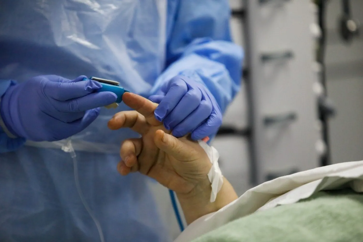 A medical worker applies a pulse oximeter to a patient in a hospital’s intensive care unit. Photo: Reuters