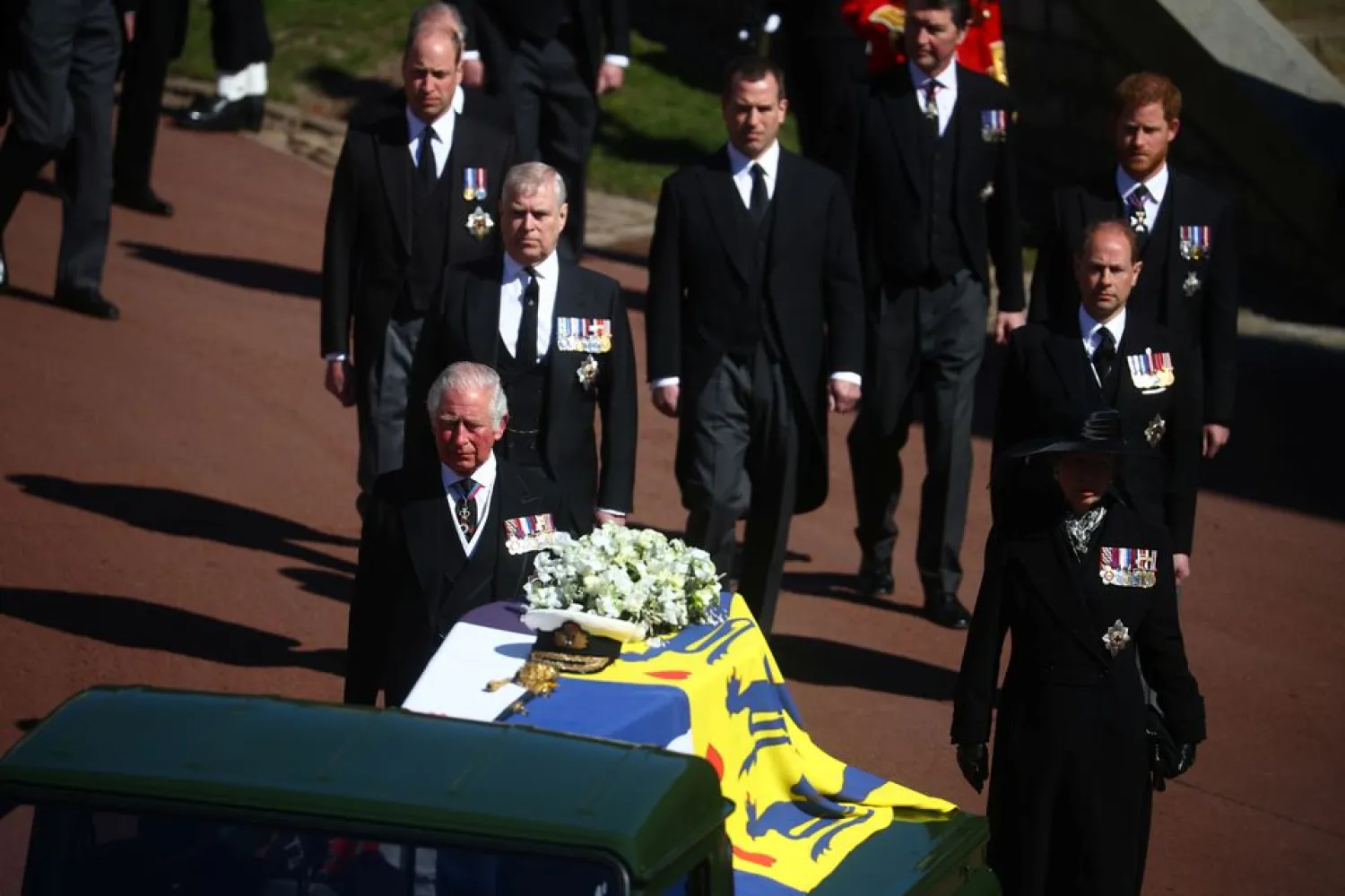 The hearse, a specially modified Land Rover, and the Royal Family walk near St George's Chapel during the funeral of Britain's Prince Philip, husband of Queen Elizabeth, who died at the age of 99, on the grounds of Windsor Castle in Windsor, Britain, April 17, 2021. (Reuters)