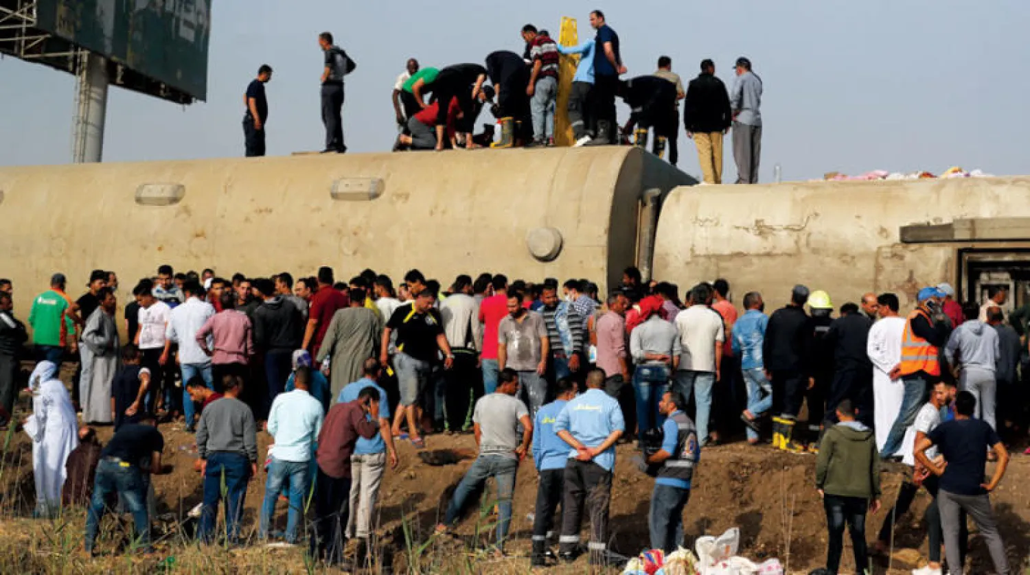 مصريون فوق عربات قطار القاهرة - المنصورة في سندهور بعد خروج 4 عجلات وانقلابها أمس (رويترز)