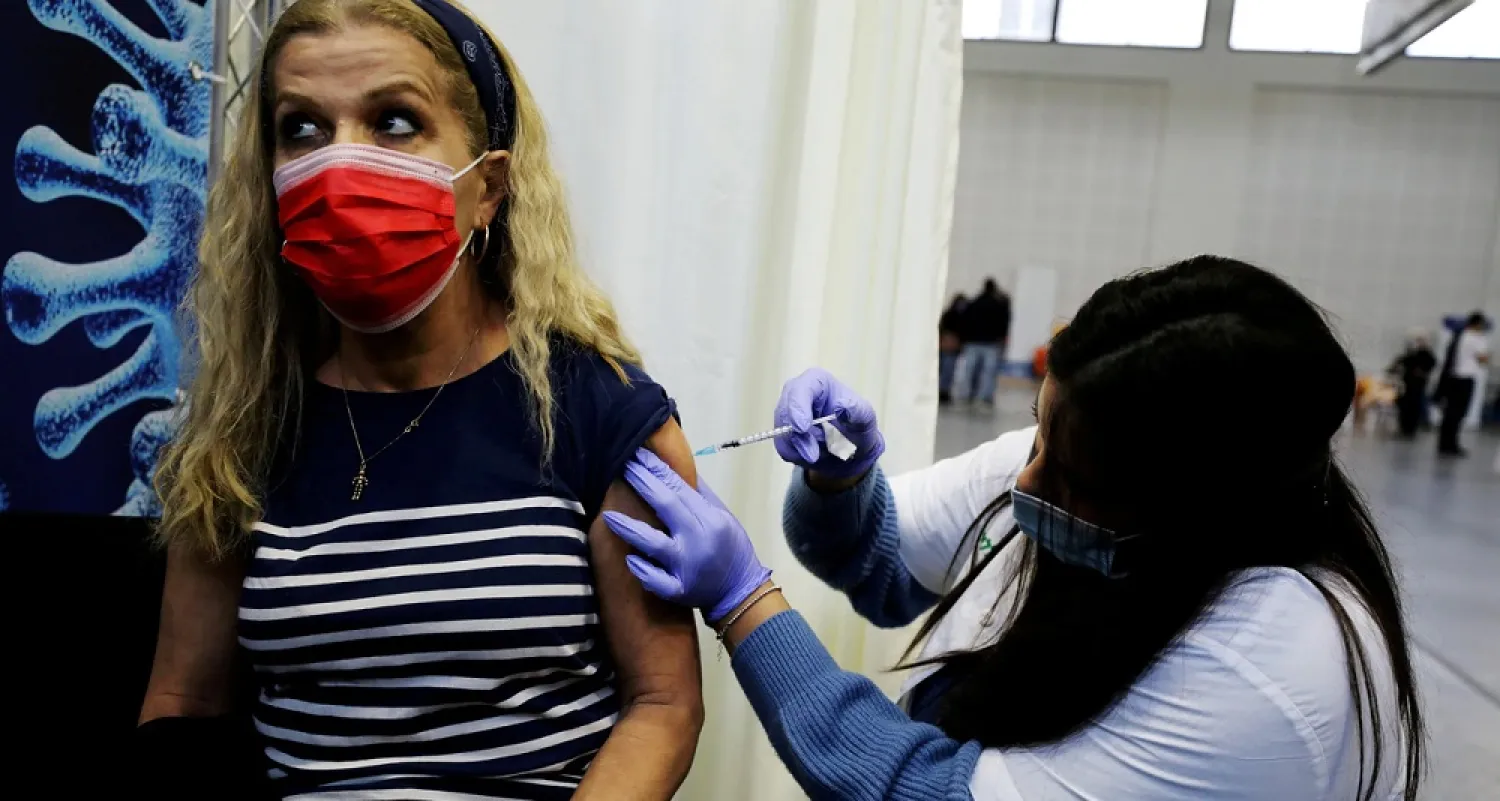 A woman receives a vaccination against COVID-19 at a temporary health care center at a basketball court in Petah Tikva, Israel, Jan. 28, 2021. (Reuters)
