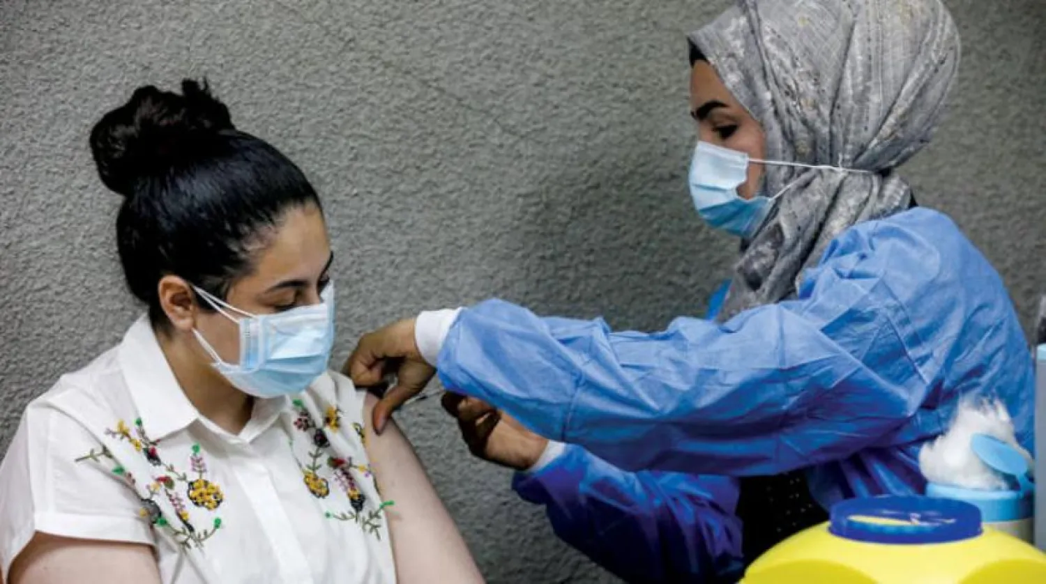 A nurse administers a dose of the Pfizer-BioNTech COVID-19 coronavirus vaccine at a vaccination center in the Kindi Hospital in Iraq's capital Baghdad on April 14, 2021. (Photo by AHMAD AL-RUBAYE / AFP)