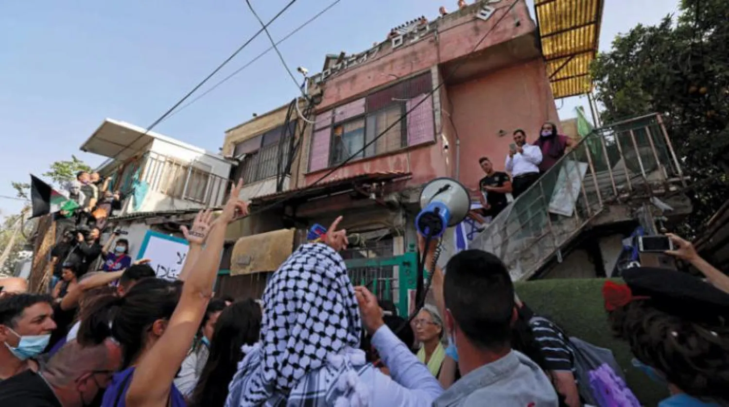 Palestinian and Israeli activists outside a settler’s house in Jerusalem protesting the eviction of citizens in Sheikh Jarrah neighborhood. (AFP)