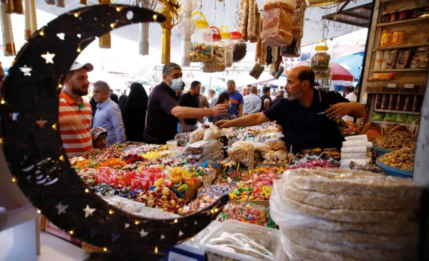 People shop at a wholesale market in Baghdad, Iraq, April 12, 2021. (Reuters)