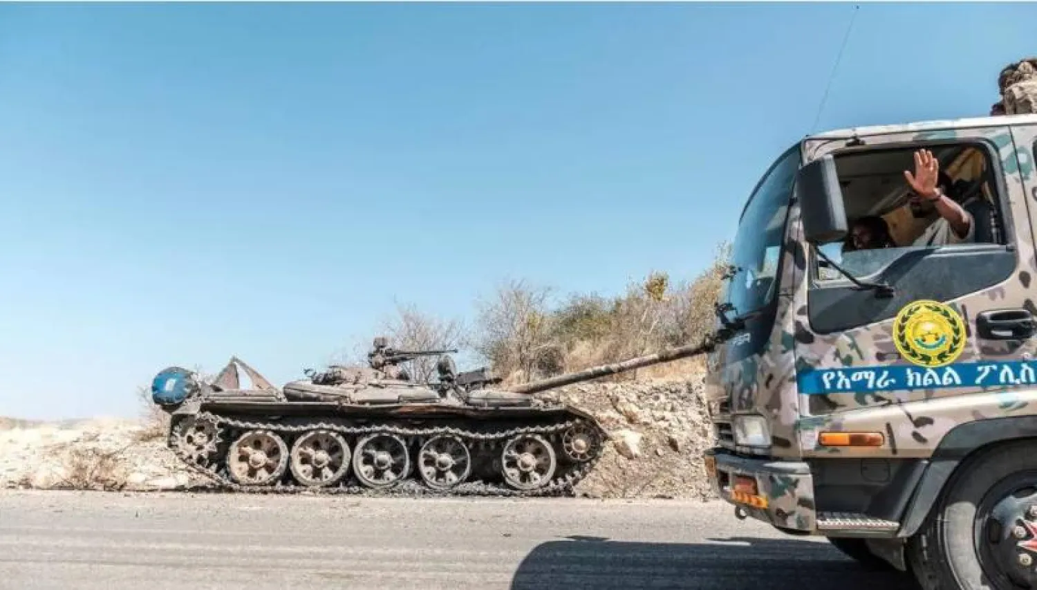 دبابة متضررة على جانب طريق أثناء مرور شاحنة تابعة لقوات أمهرة الخاصة قرب حميرة في إثيوبيا (أ.ف.ب)
