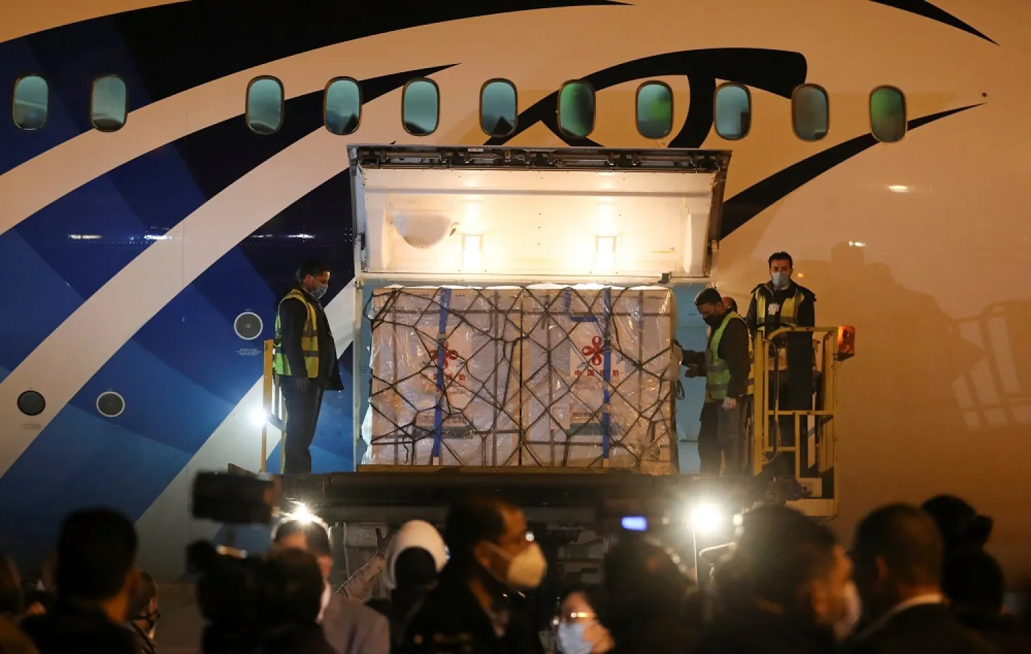 Workers offload pallets containing Sinopharm vaccine doses as they arrive from China at Cairo International Airport in Cairo, Egypt February 23, 2021. (Reuters)