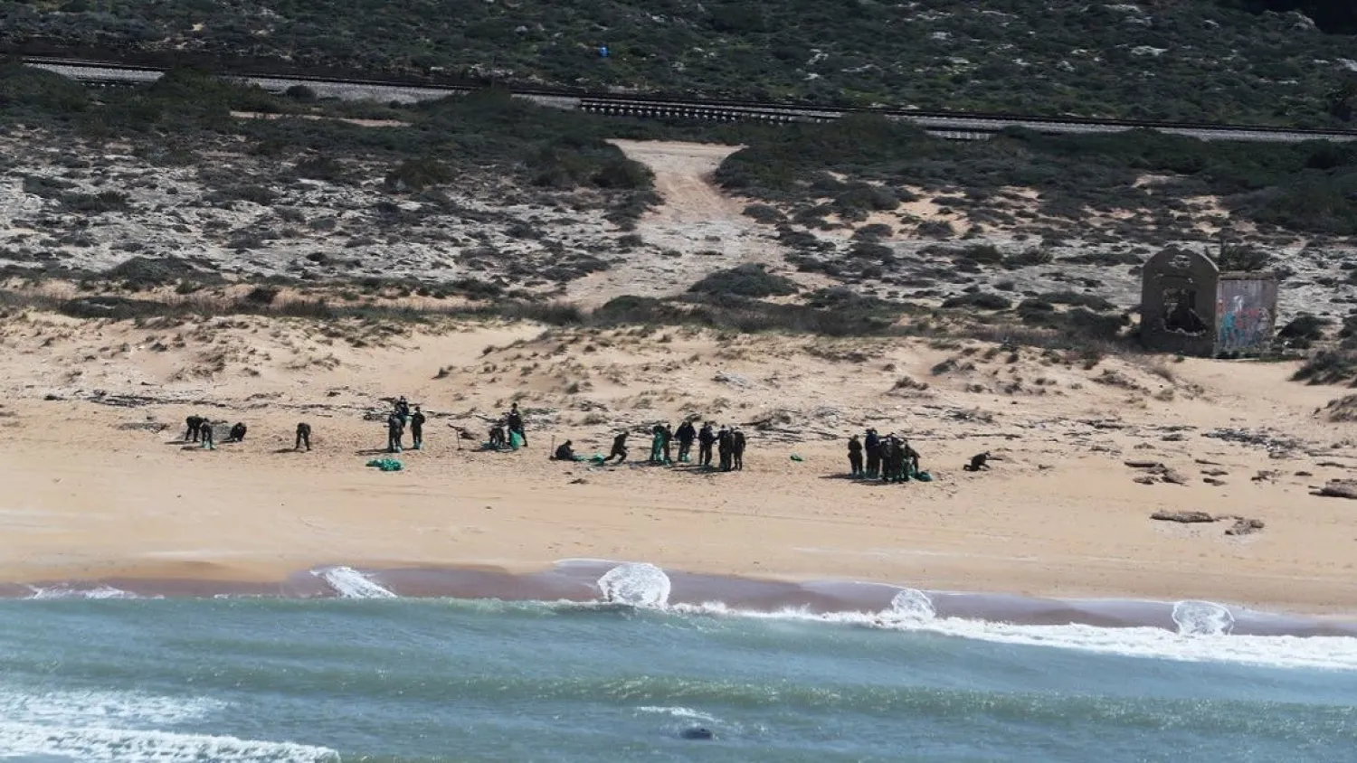 An aerial view shows Israeli soldiers cleaning from the sand on Israel's Mediterranean shoreline, at a beach in Atlit, Israel. (Reuters)
