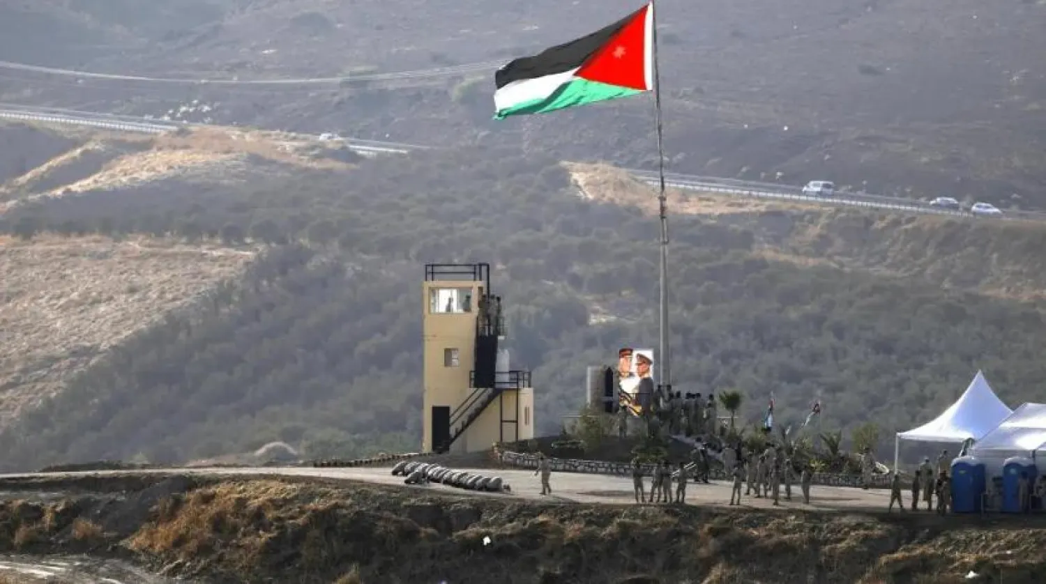   A picture taken from the Israeli side of the border shows Jordanian soldiers praying in front of a national flag during a ceremony at the Jordan Valley site of Naharayim, also known as Baqura, east of the Jordan River on November 11, 2019. (AFP)
