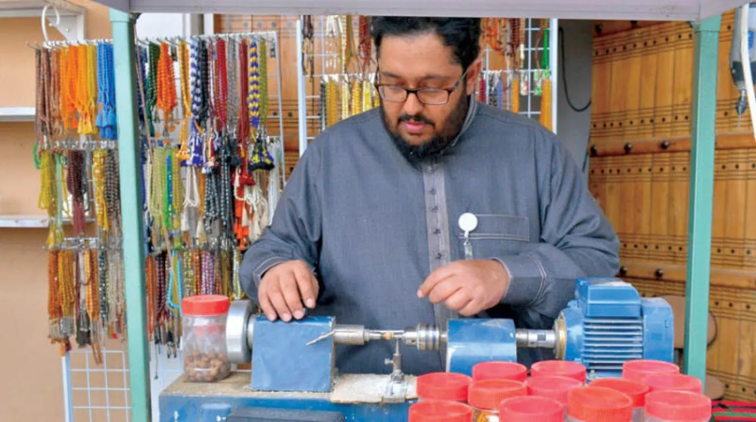 صانع السبح السعودي إبراهيم العبيداء وهو يصنع سبحة بيده في ورشته