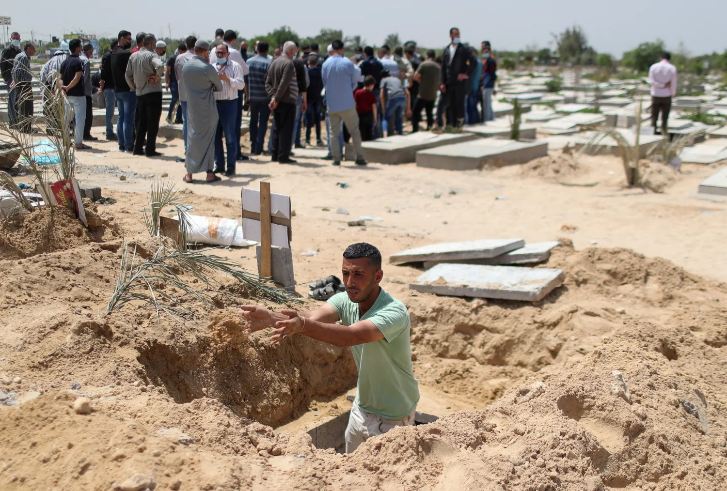 Palestinian worker Mohammad al-Haresh, 30, digs a grave for a coronavirus disease (COVID-19) victim, at a cemetery, east of Gaza City April 20, 2021. Picture taken April 20, 2021. (Reuters)
