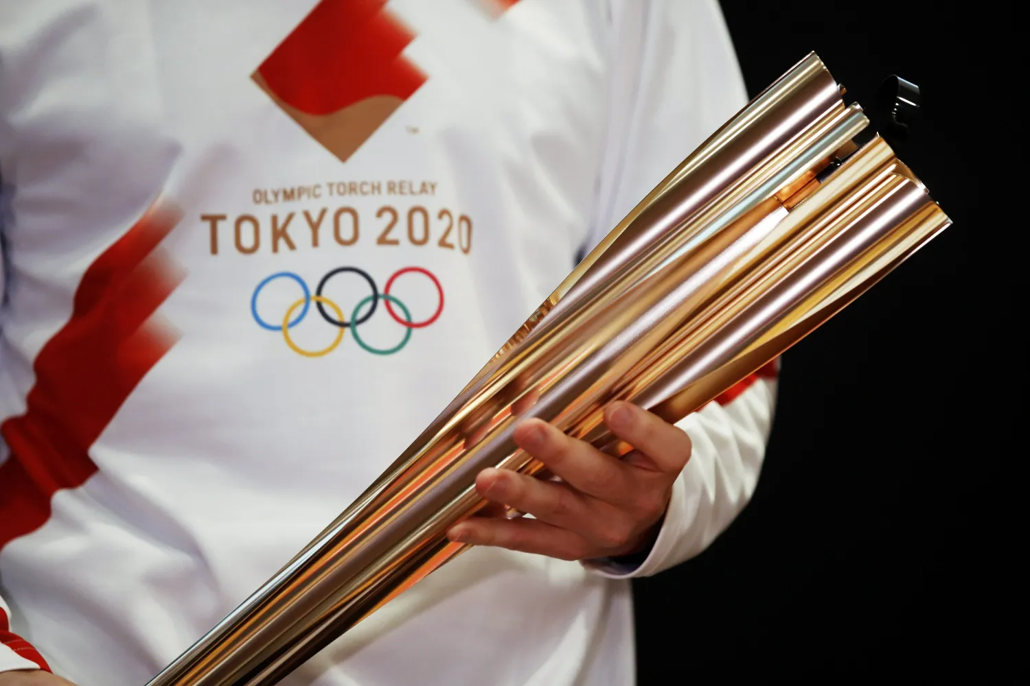 FILE - In this Feb. 24, 2020, file photo, Greek singer Sakis Rouvas wears the uniform of the torch relay runners in Athens, Greece, as he holds the torch of the 2020 Tokyo Olympic Games. AP