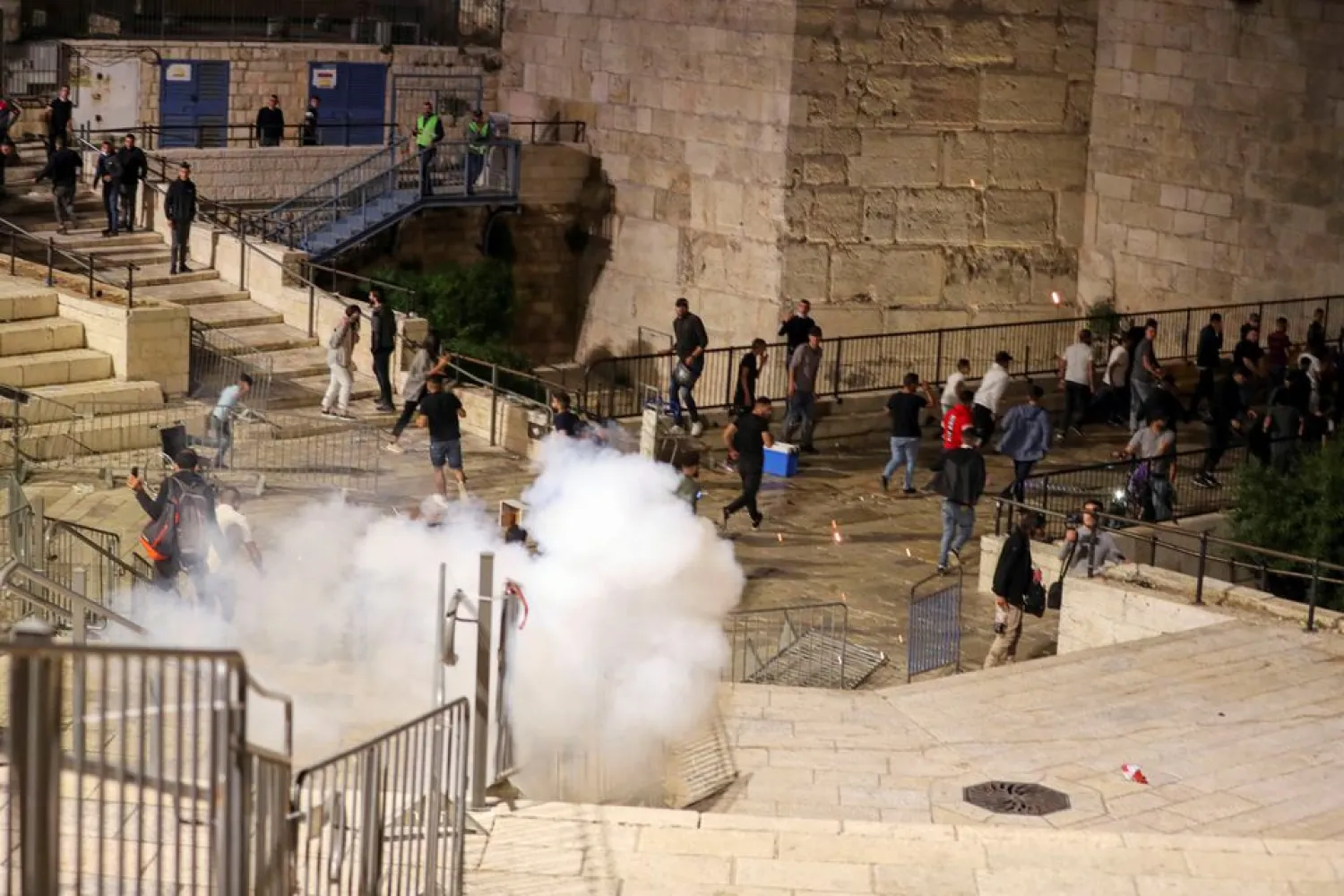 Palestinians run away as a stun grenade fired by Israeli police explodes during clashes at Damascus Gate just outside Jerusalem's Old City, on the Muslim holy fasting month of Ramadan April 17, 2021. REUTERS/Ammar Awad