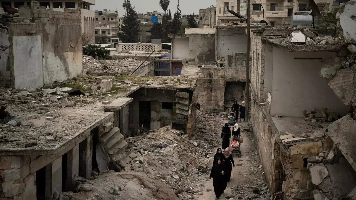 Women walk in a neighborhood heavily damaged by airstrikes in Idlib, Syria, on March 12, 2020. (AP)
