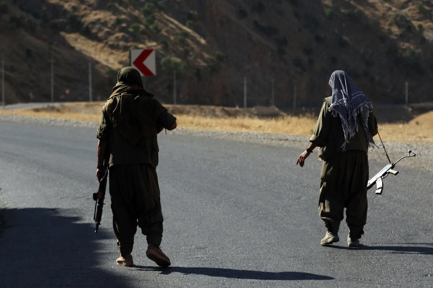 A member of the Kurdistan Workers' Party (PKK) carries an automatic rifle on a road in the Qandil Mountains, the PKK headquarters in northern Iraq, on June 22, 2018. (AFP)

