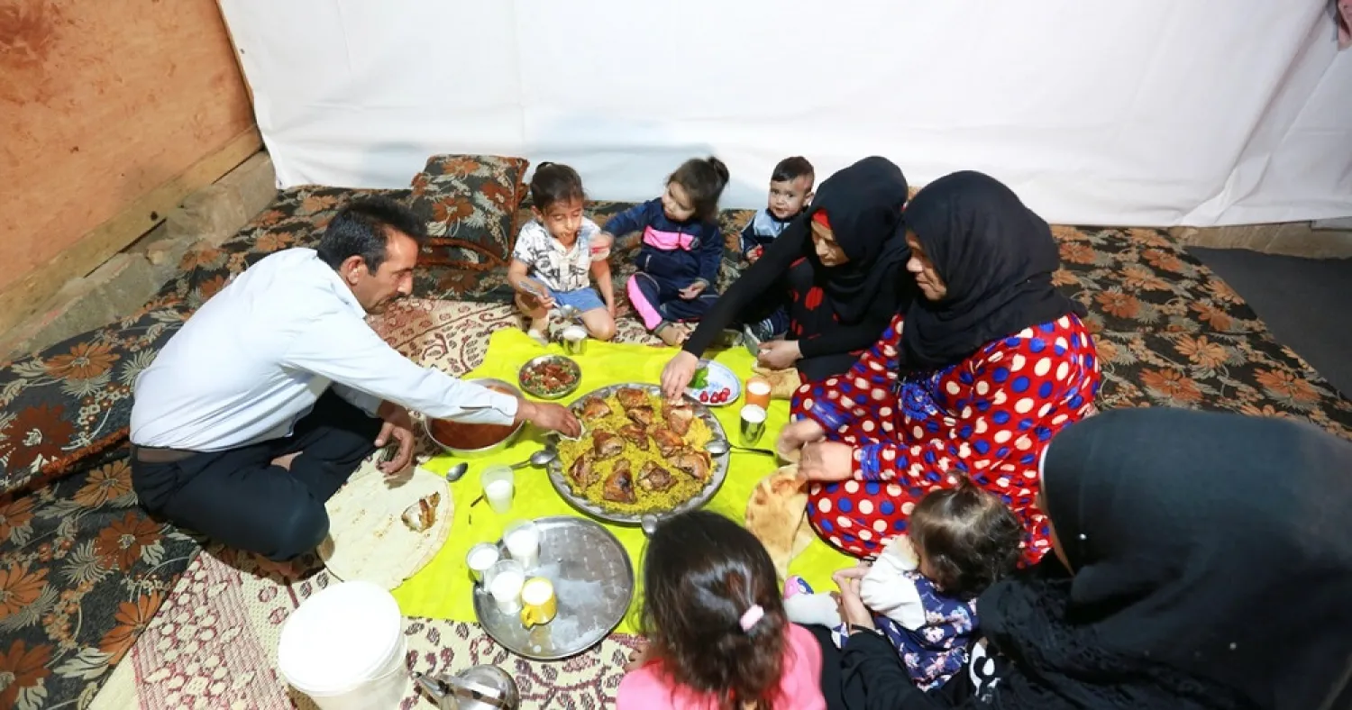 Hussein al-Khaled and his family eat their Iftar meal during Ramadan inside a tent at an informal tented settlement in Bar Elias, in the Bekaa Valley, Lebanon April 22, 2021. (Reuters)