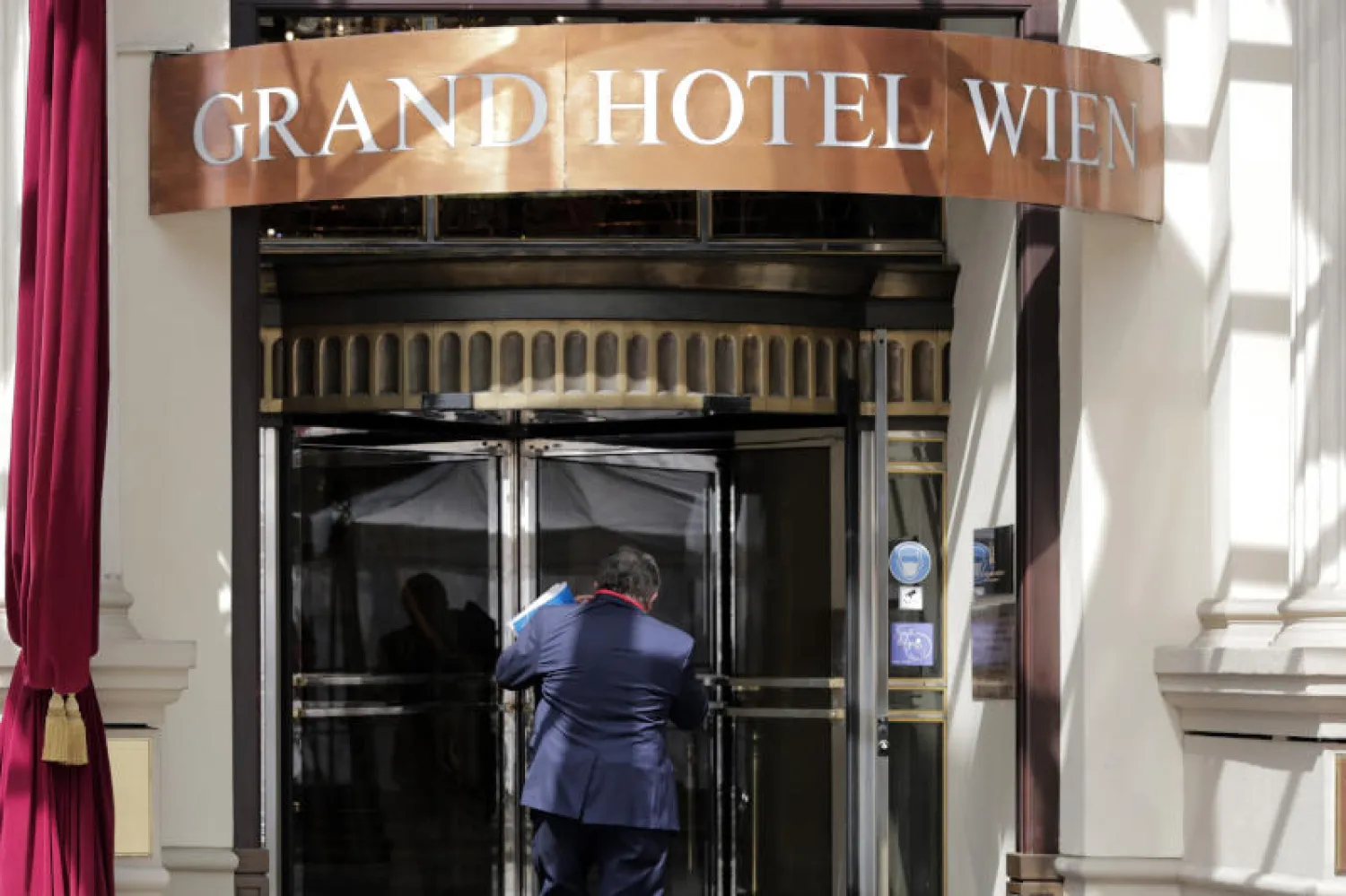 المندوب الروسي ميخائيل إليانوف يدخل الفندق حيث تجرى المفاوضات في فيينا (أ.ب)