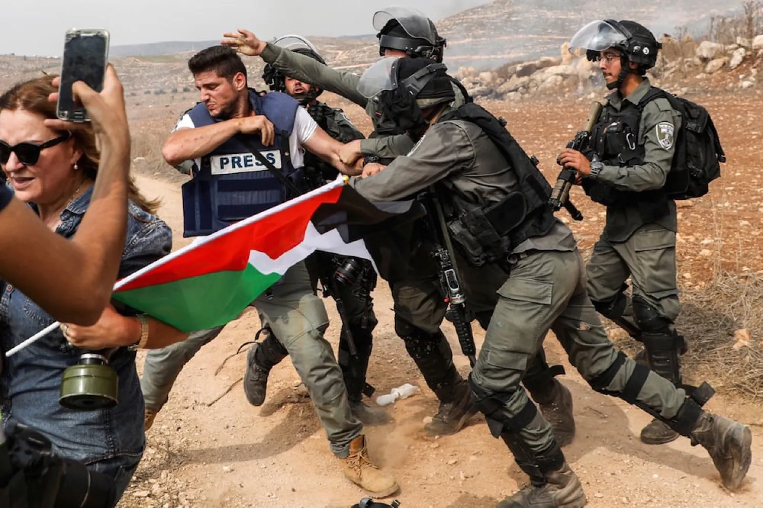 Israeli border guards assault a photojournalist during a demonstration against construction in the West Bank (October 2019, AFP)