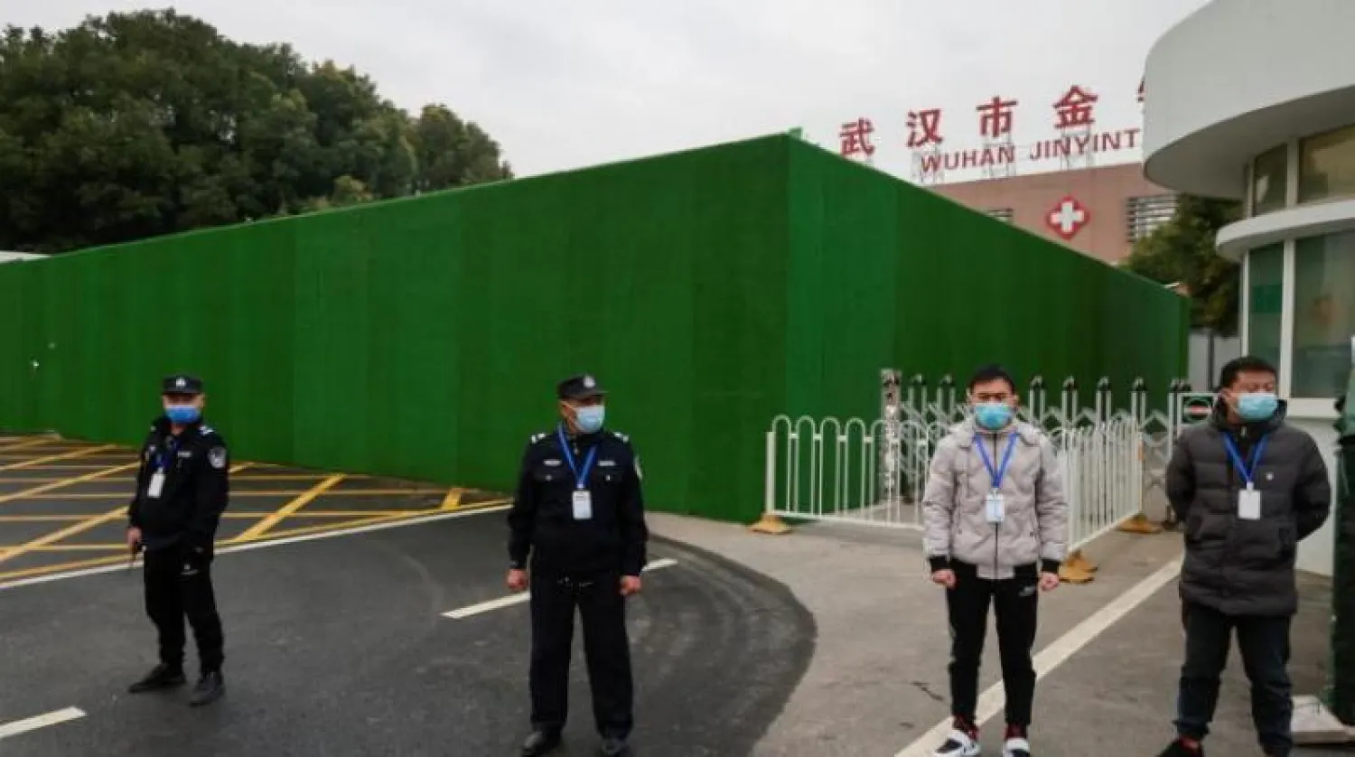 حراس الأمن يقفون خارج مستشفى «جينينتان» بعد دخول فريق من منظمة الصحة العالمية مجمّعه في ووهان (رويترز)