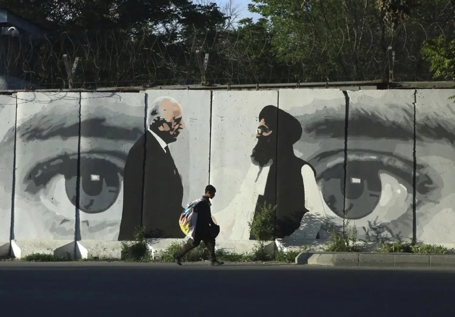 In this May 5, 2020 file photo, graffiti depicts Washington's peace envoy Zalmay Khalilzad, left, and Mullah Abdul Ghani Baradar, the leader of the Taliban delegation, in Kabul, Afghanistan. (AP)