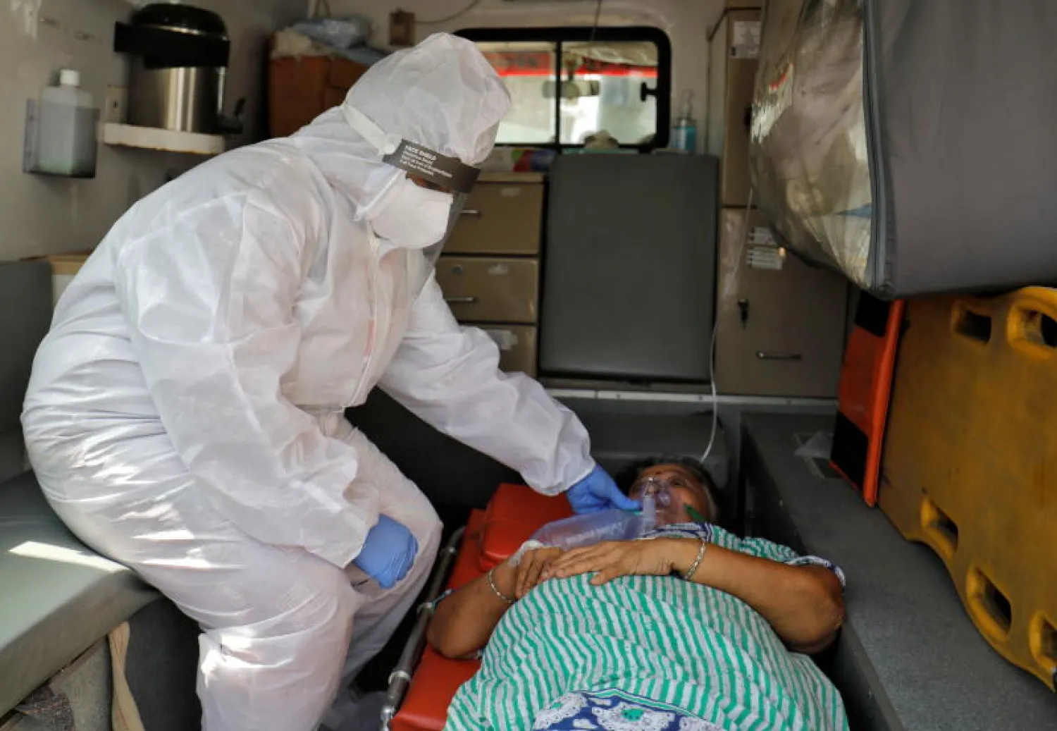 ممرضة تحاول إسعاف سيدة مصابة بكورونا في الهند (رويترز)