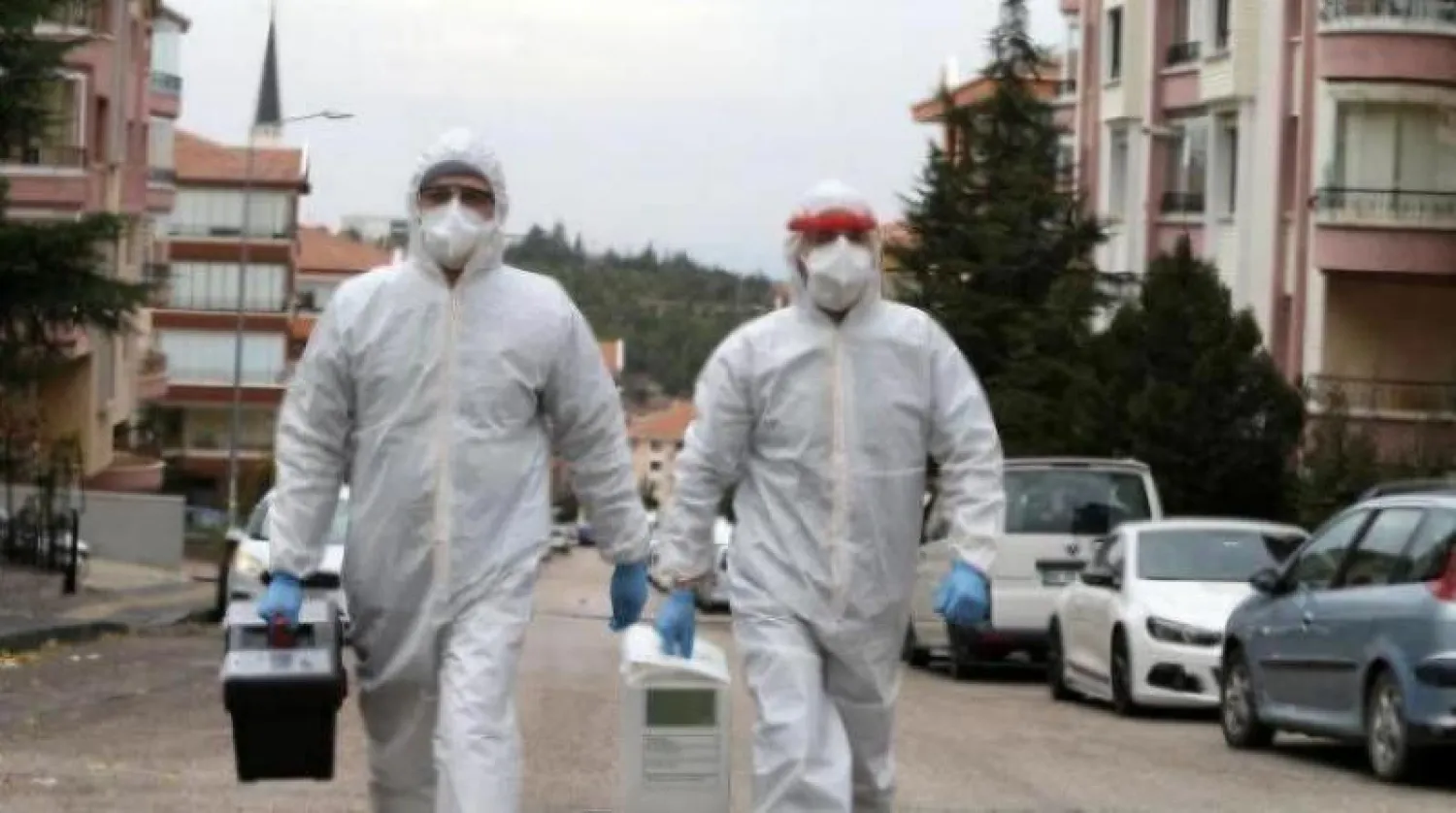 عاملا رعاية صحية يرتديان ملابس واقية في طريقهما إلى مصاب بـ«كورونا» في أنقرة (أ.ف.ب)