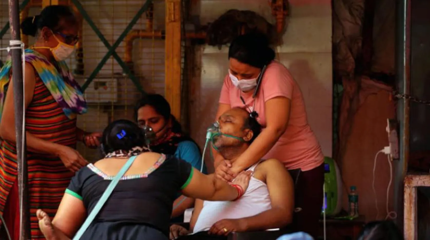 Dün Ghaziabad’da koronavirüse yakalanmasının ardından nefes darlığı yaşayan adama kızı destek olurken (Reuters)