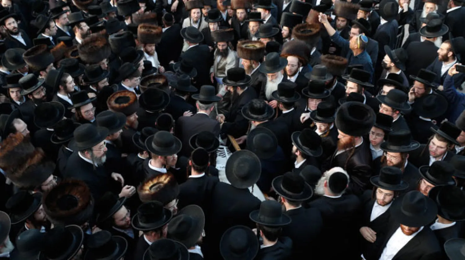 يهود أرثوذكس يشاركون في دفن أحد ضحايا حادث التدافع بالقدس أول من أمس (إ.ب.أ)