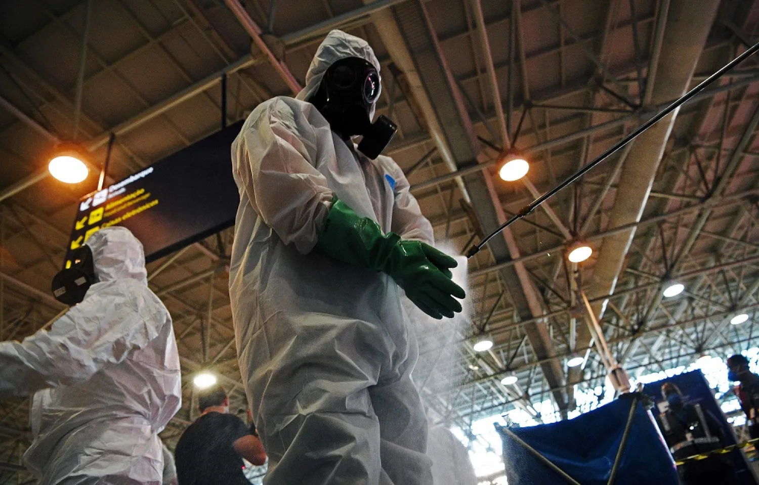 A soldier disinfects his gloves after carrying out a disinfection operation against COVID-19 at Tom Jobim Galeao International Airport in Rio de Janeiro, Brazil, on April 24, 2020. (AFP)