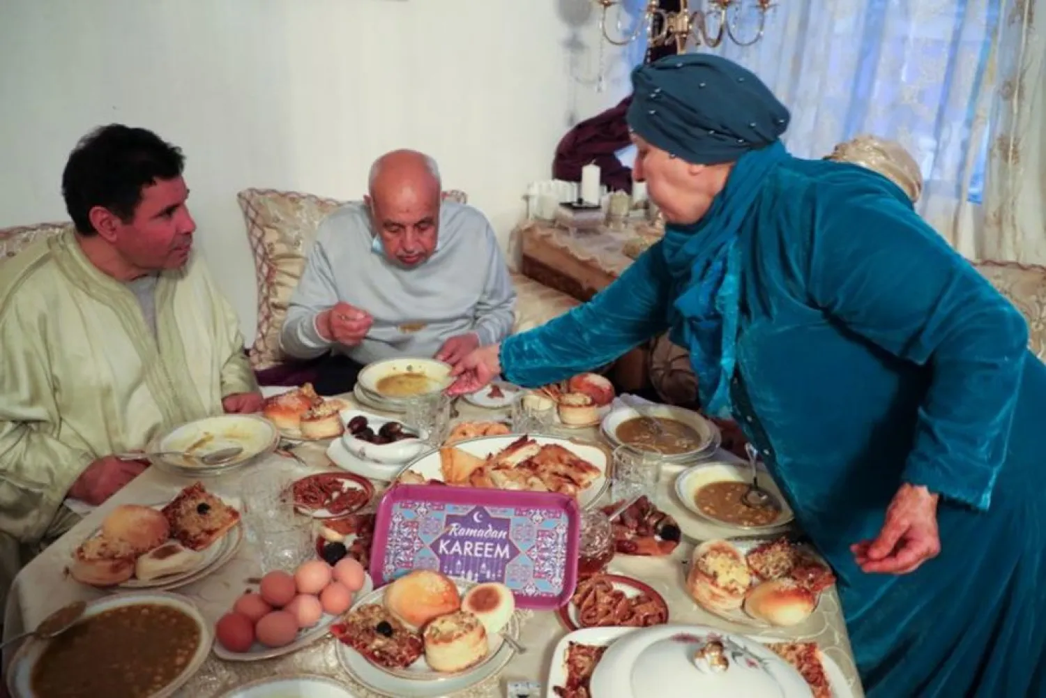 Muslim family including Aziz Moujahid, his wife Lalla Aicha Moujahid and two friends of the family Abdullah and Rabiah break fast at Ramadan during the nationwide curfew from 7 pm to 6 am, and under restrictions limiting gatherings at houses up to 6 people due to tighter measures against the spread of coronavirus disease (COVID-19), in Aulnay-sous-Bois near Paris, France, May 1, 2021. REUTERS/Yiming Woo
