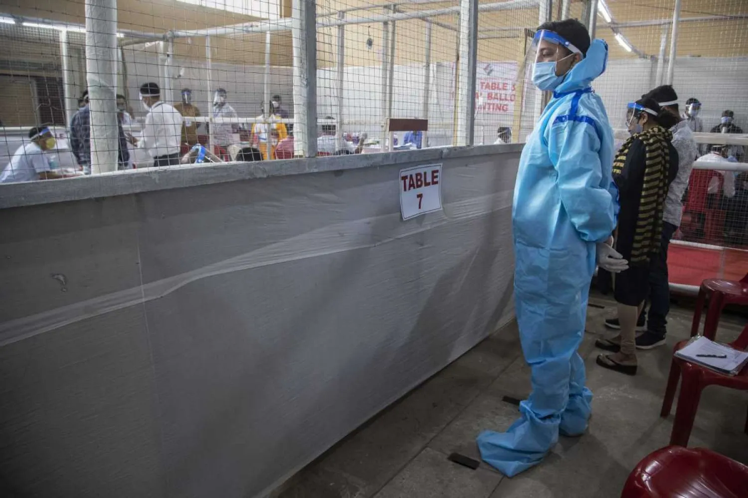A counting agent stands in protective suit during the counting of votes of Assam state assembly election in Gauhati, India, Sunday, May 2, 2021. With Indian hospitals struggling to secure a steady supply of oxygen, and more COVID-19 patients dying amid the shortages, a court in New Delhi said it would start punishing government officials for failing to deliver the life-saving items. (AP Photo/Anupam Nath)