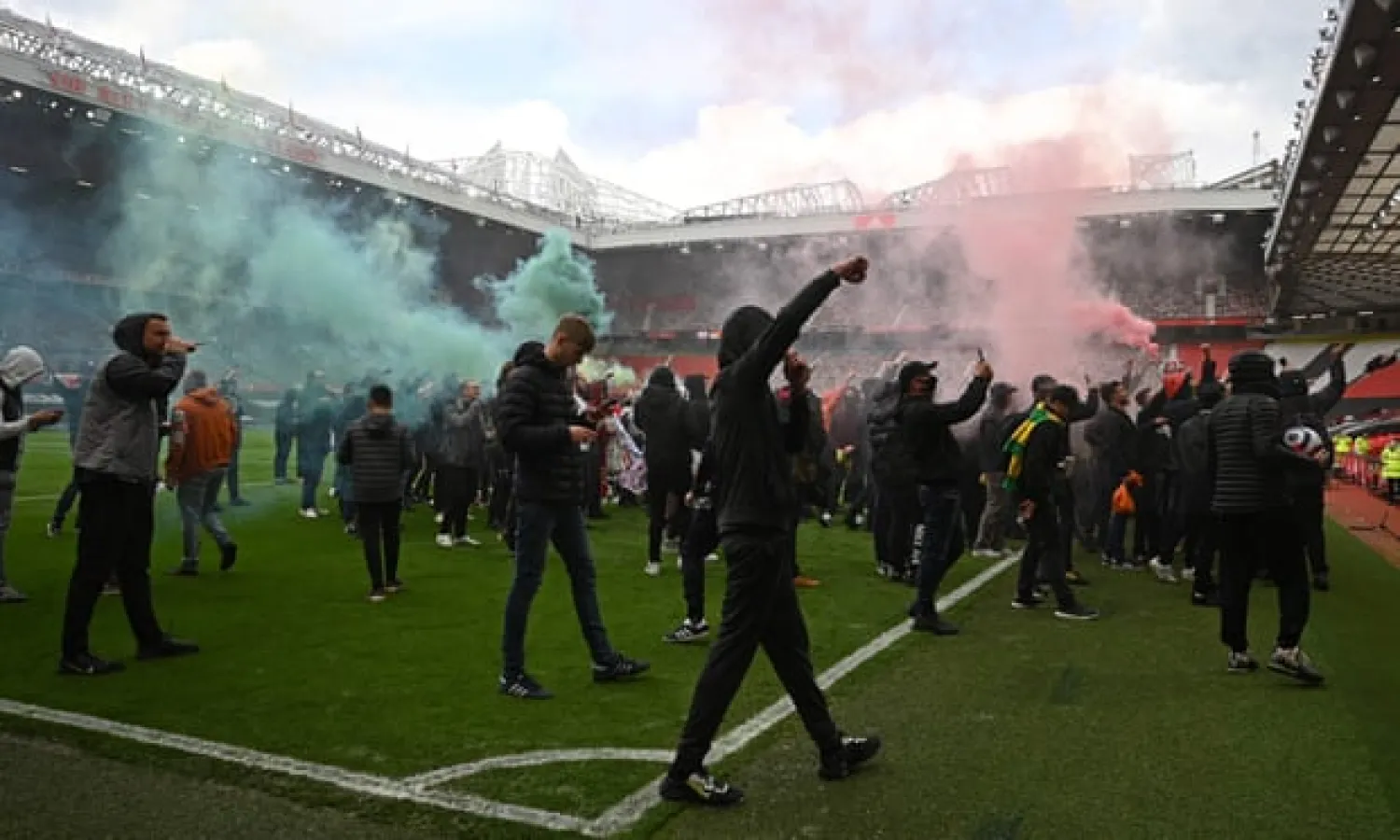 Manchester United supporters on the Old Trafford pitch. Photograph: Oli Scarff/AFP/Getty Images
