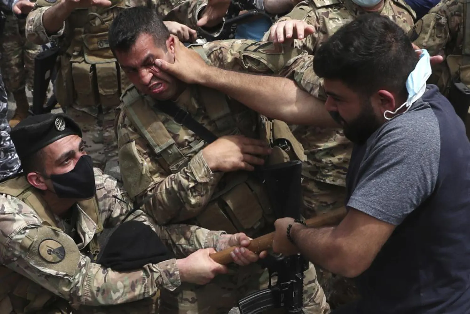 FILE - In this April 19, 2021 file photo, opponents of Judge Ghada Aoun scuffle with army soldiers during a sit-in outside the Justice Palace in Beirut, Lebanon.  (AP Photo/Bilal Hussein, File)
