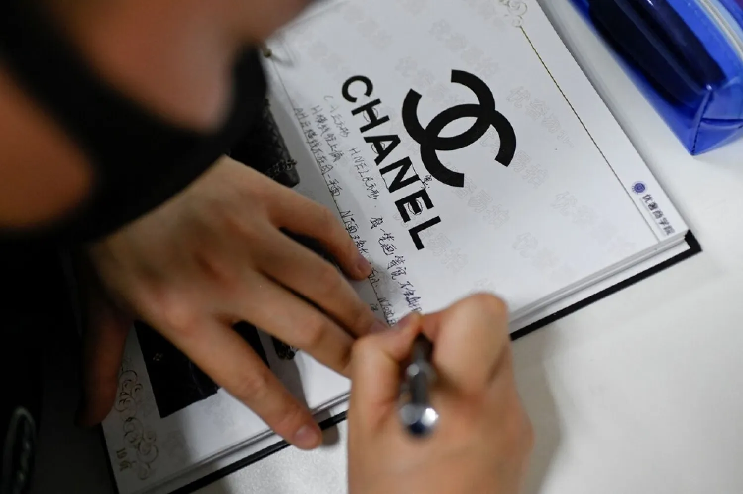 A trainee taking notes during a class at the Extraordinary Luxuries Business School in Beijing on March 24, 2021. (AFP)