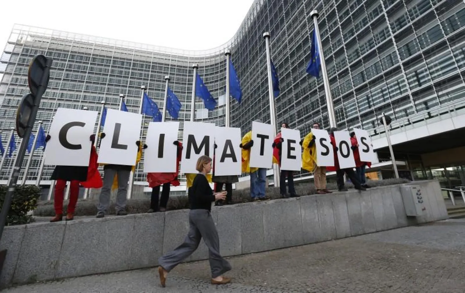 Members of environmental associations hold signs as they gather to demand improvements in climate change and energy models, outside the European Commission headquarters during the presentation of the 2030 Framework for Climate and Energy EU2030 in Brussels January 22, 2014. REUTERS/Yves Herman