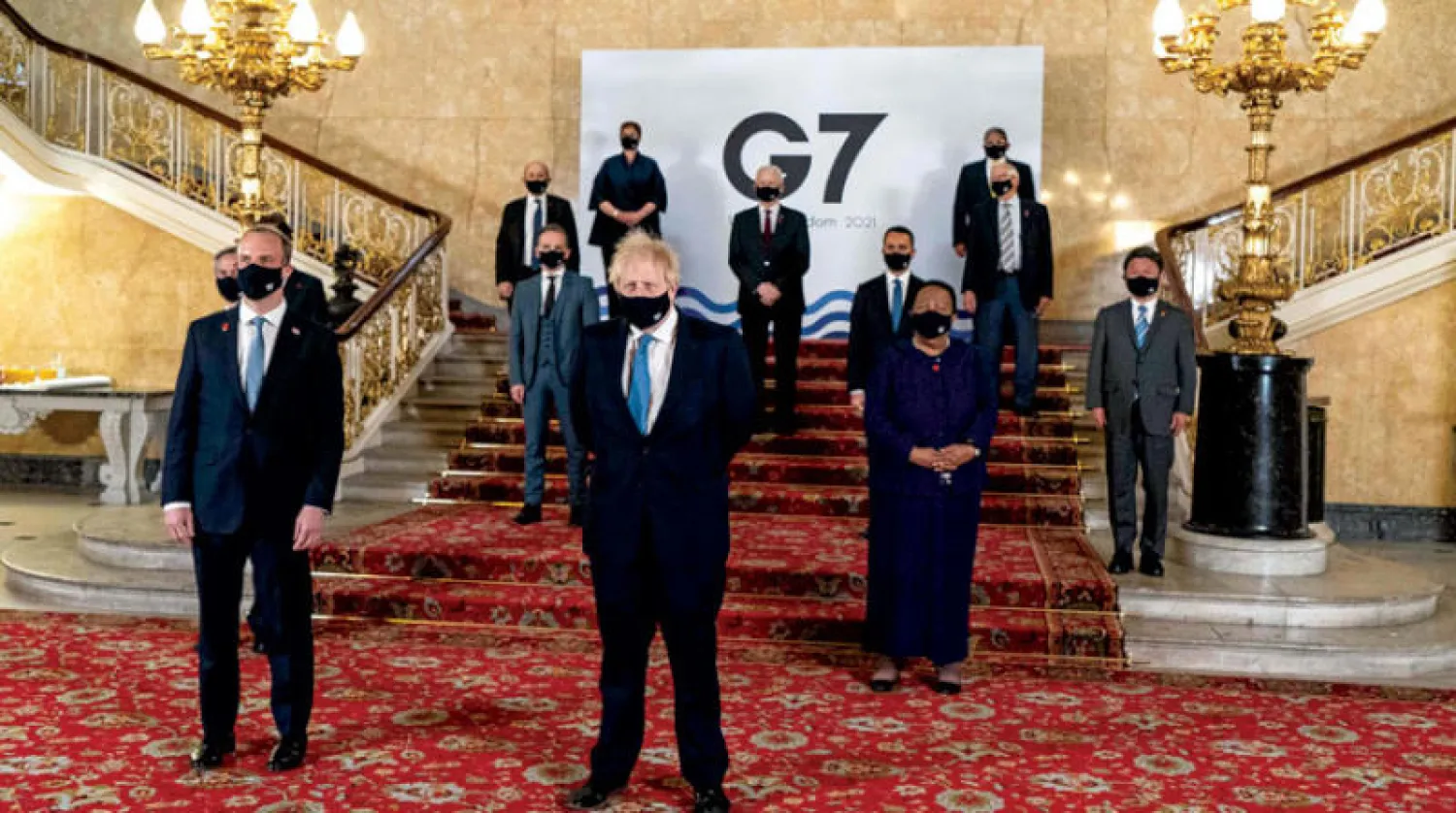 رئيس وزراء بريطانيا بوريس جونسون (وسط) مع أعضاء الوفود المشاركة (أ.ف.ب)