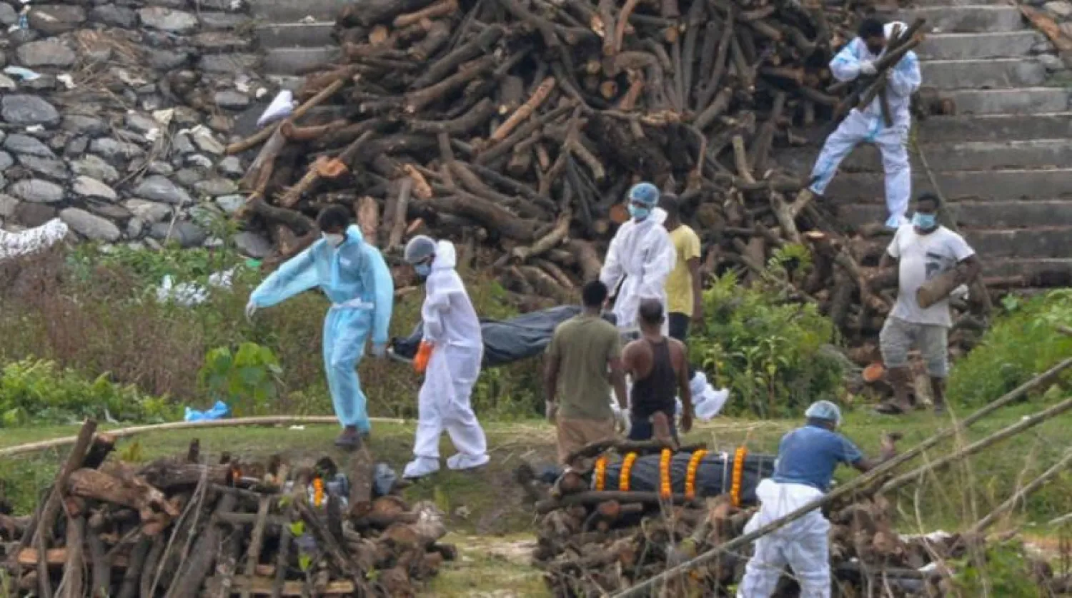  Hindistan’da kororonavirüs kurbanlarının cesetlerini yakmak için hazırlanan çalışanlar (AFP)
