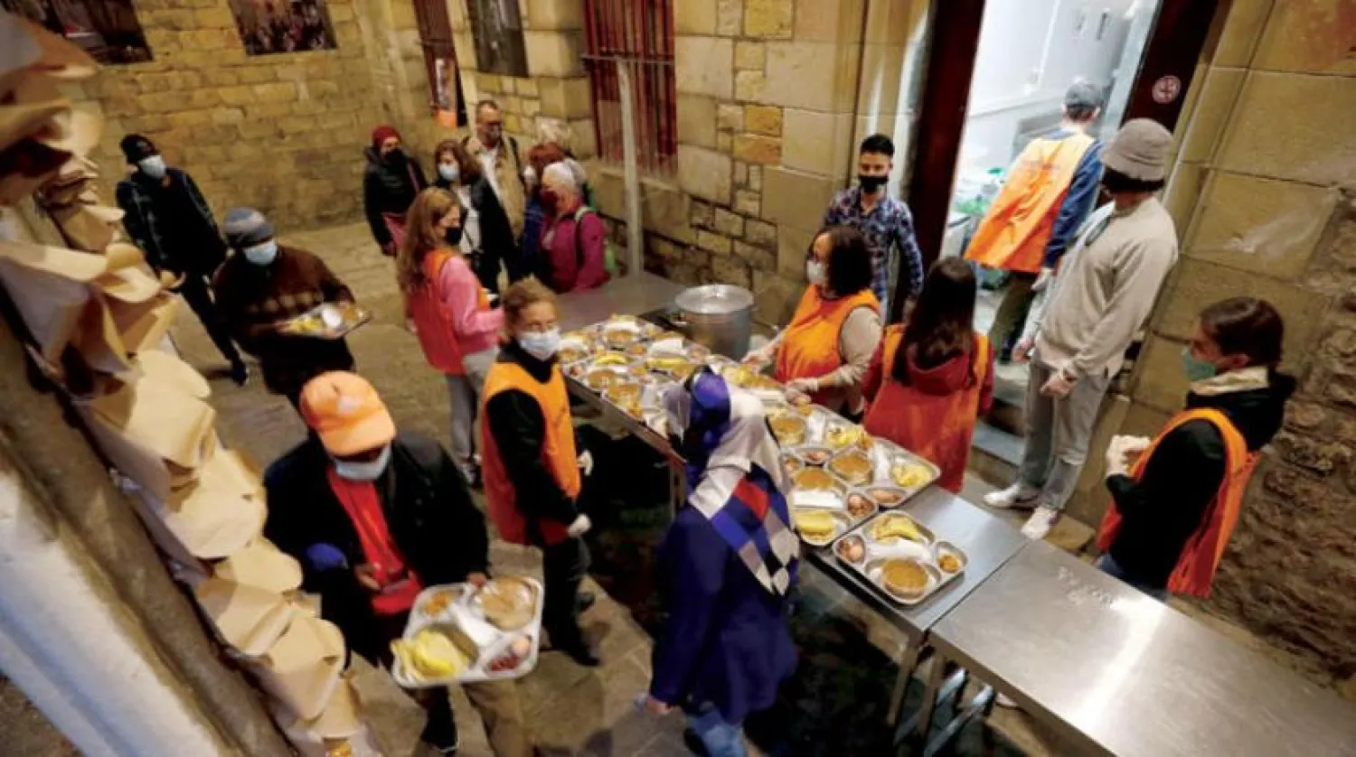 People carry food trays during a charity Ramadan Iftar in the cloister at Santa Anna church during the coronavirus disease (COVID-19) outbreak, in Barcelona, Spain, April 28, 2021. REUTERS/Albert Gea