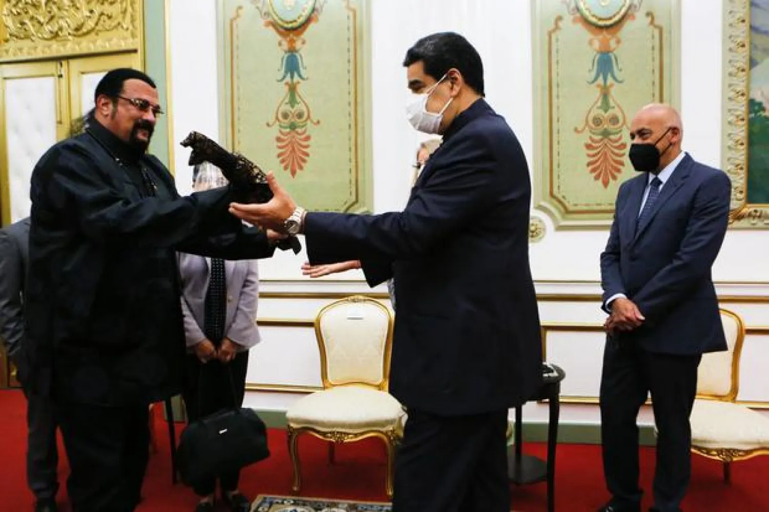 Handout picture released by the Venezuelan Presidency press office showing Venezuelan President Nicolas Maduro (R) shaking hands with US actor Steven Seagal during a meeting at the Miraflores presidential palace in Caracas, on May 4, 2021. (Photo by Handout / Venezuelan Presidency / AFP)